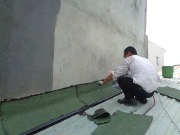 Thợ thi công đóng màng tôn ốp khe chữ V chống thấm khe lún giữa 2 nhà liền kề